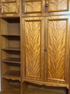 a wooden closet with wooden doors and shelves at Green side in Ganja