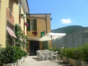 a patio with an umbrella and tables and chairs at Hotel Lea in Grosseto