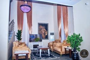 ein Wohnzimmer mit Sofas und einem Fernseher in der Unterkunft Ozigrand Hotel in Benin-Stadt
