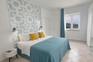 a bedroom with a bed with yellow pillows and a window at Villa Raf in Vico Equense