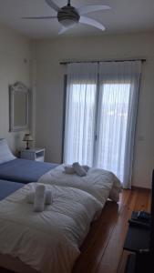 ein Schlafzimmer mit zwei Betten und einem Deckenventilator in der Unterkunft Aeria View in Éva + 53 Fotos