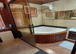 a bath tub in a bathroom with a shower at Pousada requinte serrano in Urubici +54 photos