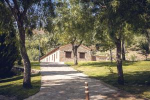 a stone building in a park with trees at Apartamentos El Escondite de Pedro Malillo in Candeleda