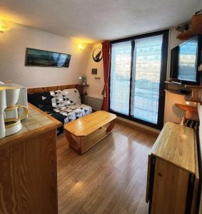 a living room with a couch and a table at Cocon Montagne Vue exceptionnelle Pra-Loup 1500 in Uvernet
