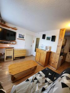 a living room with a coffee table and a flat screen tv at Cocon Montagne Vue exceptionnelle Pra-Loup 1500 in Uvernet