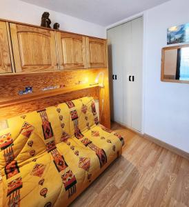 a bedroom with a bed with a yellow blanket at Cocon Montagne Vue exceptionnelle Pra-Loup 1500 in Uvernet