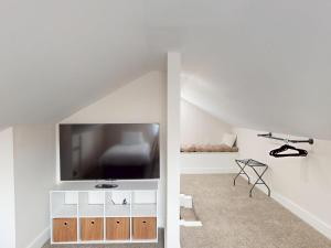 a living room with a flat screen tv on a white wall at The Nook on Landess in Marion