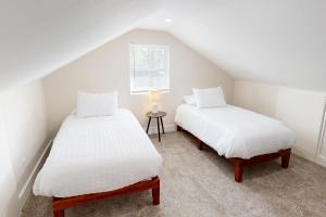 two twin beds in a attic bedroom with a window at The Nook on Landess in Marion