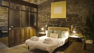 a bedroom with a bed with towels on it at Pazo de San Pedro de Bembibre in Taboada
