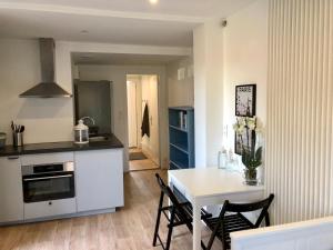 a kitchen and dining room with a white table and chairs at Le Petit Ekrin des Ursines in Vélizy-Villacoublay