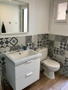 a bathroom with a white sink and a toilet at Le Petit Ekrin des Ursines in Vélizy-Villacoublay