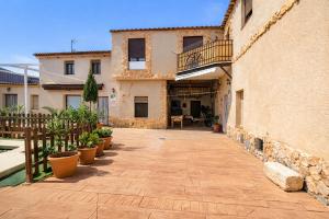 a courtyard of a house with potted plants at Casa Rural la Quinteria de Sancho piscina para tres apartamentos in Argamasilla de Alba