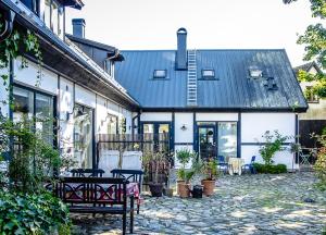 a building with benches and tables in a courtyard at Apan & Klyset in Simrishamn