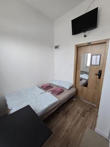 a bedroom with a bed and a door with a television at Mini nocleg przy dworcu in Tomaszów Mazowiecki +10 photos