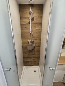 a shower with a glass door and a sink at Mini nocleg przy dworcu in Tomaszów Mazowiecki