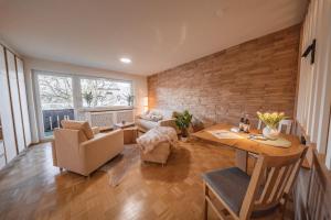 ein Wohnzimmer mit Tisch, Stühlen und Sofa in der Unterkunft Moderne Ferienwohnung mit Ifenblick, Panorama & Parkplatz in Oberstdorf