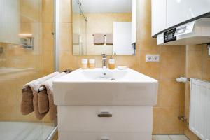 ein Badezimmer mit weißem Waschbecken und Dusche in der Unterkunft Moderne Ferienwohnung mit Ifenblick, Panorama & Parkplatz in Oberstdorf + 40 Fotos
