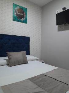 a bedroom with a white bed with a blue headboard at Bahia Suite Alojamiento Centro historico in Santa Marta +11 photos