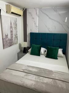 a bedroom with a large bed with a blue headboard at Bahia Suite Alojamiento Centro historico in Santa Marta