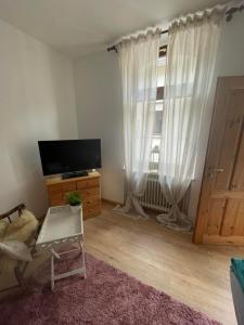 a living room with a tv and a window at Gasthaus Liam 2 in Bendorf