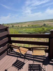 a bench sitting on a deck looking out over a field at Danube Delta View in Dunavăţu de Jos