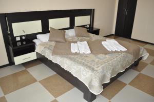 a bedroom with a large bed with two towels on it at Anna Mariya Villa in Kurortne