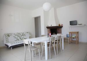 a white dining room with a white table and chairs at Casa Solento in Campomarino
