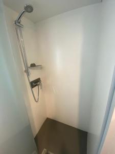 a shower in a bathroom with a white wall at Camping Mayotte, Biscarosse in Biscarrosse