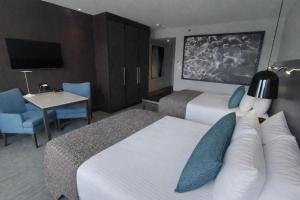 a hotel room with two beds and a desk and a tv at Taboo Muskoka in Gravenhurst