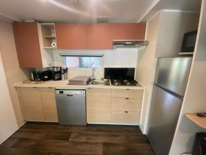 a small kitchen with a sink and a refrigerator at Camping Mayotte, Biscarosse in Biscarrosse