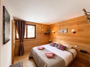 a bedroom with a large bed with two pink pillows at Duplex Les Gets Centre Local VTT Sécurisé & Balcon 6P in Les Gets