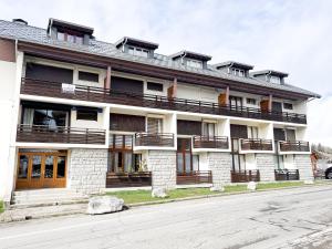 a building with balconies on the side of a street at Duplex Les Gets Centre Local VTT Sécurisé & Balcon 6P in Les Gets