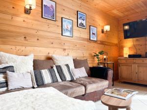 a living room with a couch and a tv at Duplex Les Gets Centre Local VTT Sécurisé & Balcon 6P in Les Gets