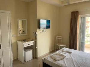 a bedroom with a bed and a television on the wall at Honey Residence in Sarandë