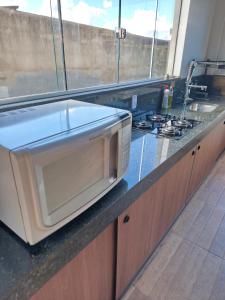 a microwave sitting on a counter in a kitchen at Quatro com suite e cozinha in Brumadinho