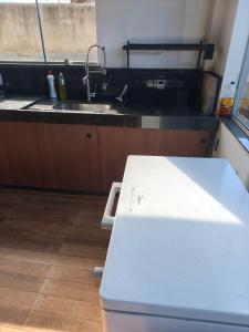 a kitchen with a sink and a counter top at Quatro com suite e cozinha in Brumadinho