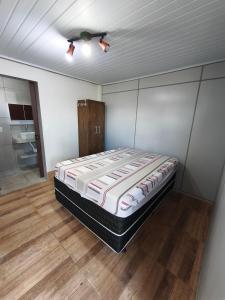 a bed in a room with a ceiling fan at Quatro com suite e cozinha in Brumadinho