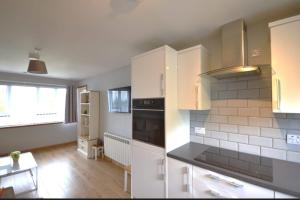 a kitchen with white cabinets and a stove top oven at Cozy 1 bed flat in Stornoway in Stornoway
