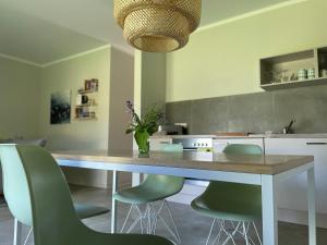 a kitchen with a table and some green chairs at Ferienwohnung VIER Hof Himmelgrün in Saal +34 photos