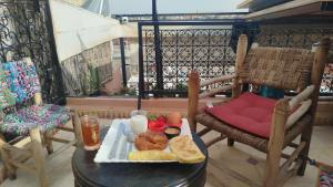 ein Tablett mit Essen auf einem Tisch auf einem Balkon in der Unterkunft Riad Hostel ADI in Marrakesch