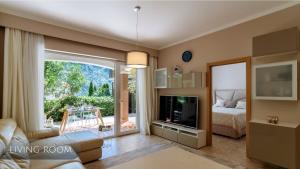 a living room with a couch and a television at Private Terrace Living - Blue Flag Beach & Family Retreat near Kotor in Gornji Orahovac