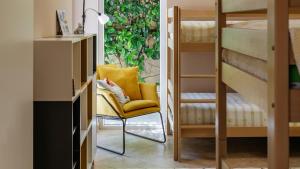 a yellow chair in a room with bunk beds at Private Terrace Living - Blue Flag Beach & Family Retreat near Kotor in Gornji Orahovac +37 photos