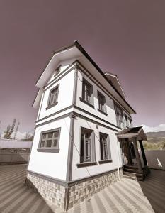a small white building with a door and windows at Hotel Riverwood Kokernag in Wāngom
