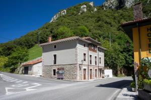 a building on the side of a road with a mountain at Hotel Boutique Las dos Peñas in Mier