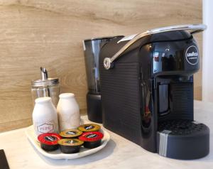 a coffee maker with cupcakes on a tray next to a coffee pot at Prime Location Apartment Vilnius in Vilnius