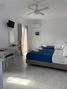 a bedroom with a bed and a ceiling fan at Moschoula Studios in Parikia