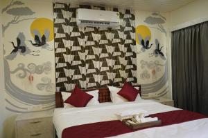 a bedroom with a large bed with red pillows at Eleven Eleven Villa in Pondicherry