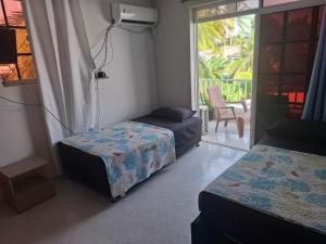 a bedroom with two beds and a balcony at Habitaciones Casa Lisboa in San Andrés