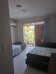 a bedroom with two beds and a view of a patio at Habitaciones Casa Lisboa in San Andrés