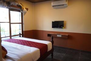 a bedroom with a bed and a tv on the wall at Eleven Eleven Villa in Pondicherry